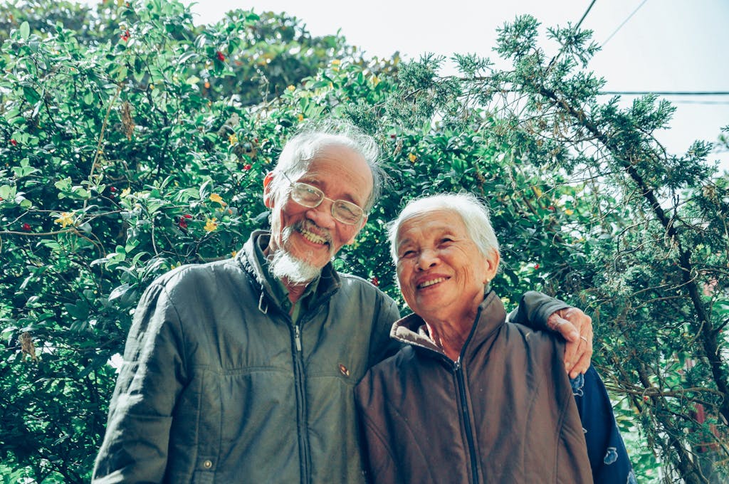 Senior couple enjoying a joyful moment together in a lush garden setting, exuding love and happiness from Medicare Planning.