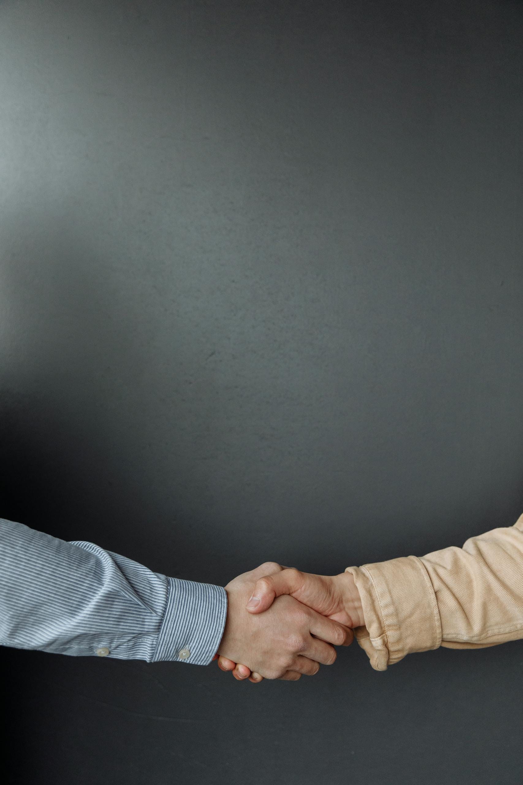 A close-up of two adults shaking hands, symbolizing agreement and partnership. For marketplace Plans