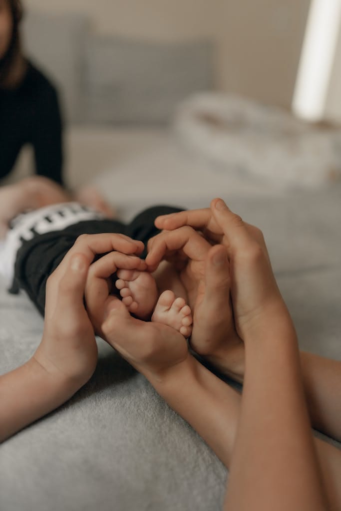 Close-up of adult and child hands gently holding baby feet, creating a heart shape. Knowing they got life insurance