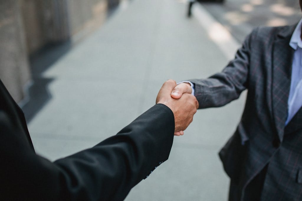 Close-up of two businessmen shaking hands outside, symbolizing partnership and agreement. for Life insurance